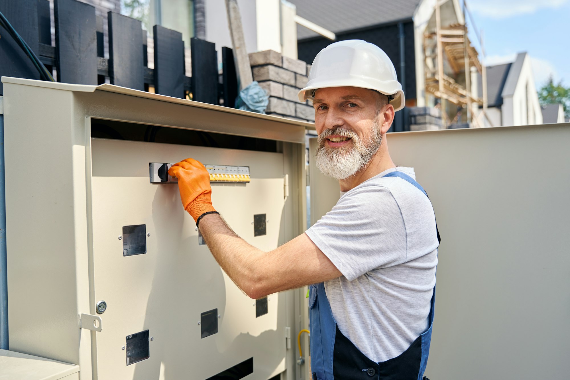 Pleased electrical engineer restoring electricity supply to house