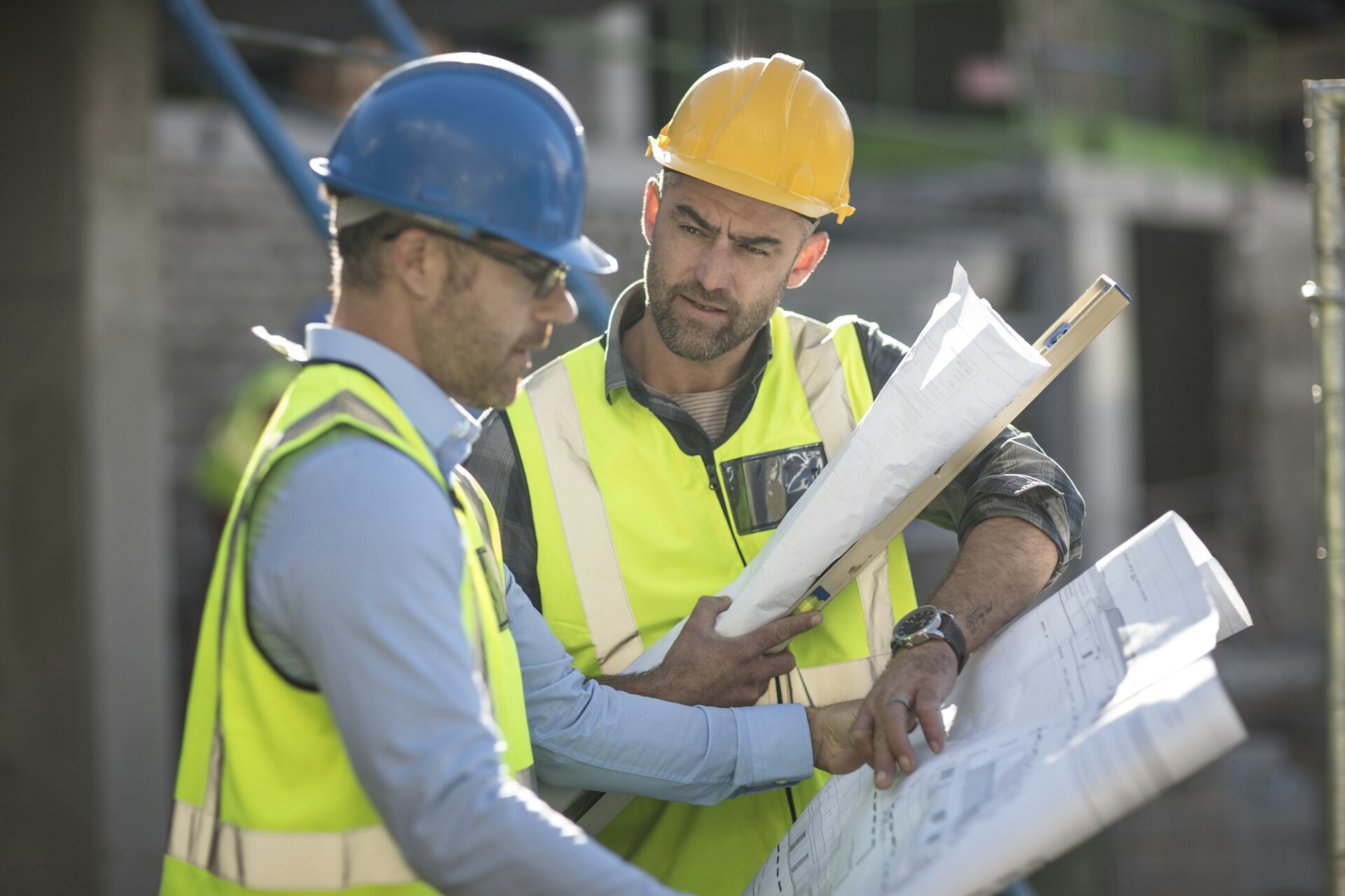 Projektleiter und Bauarbeiter sehen sich Pläne an