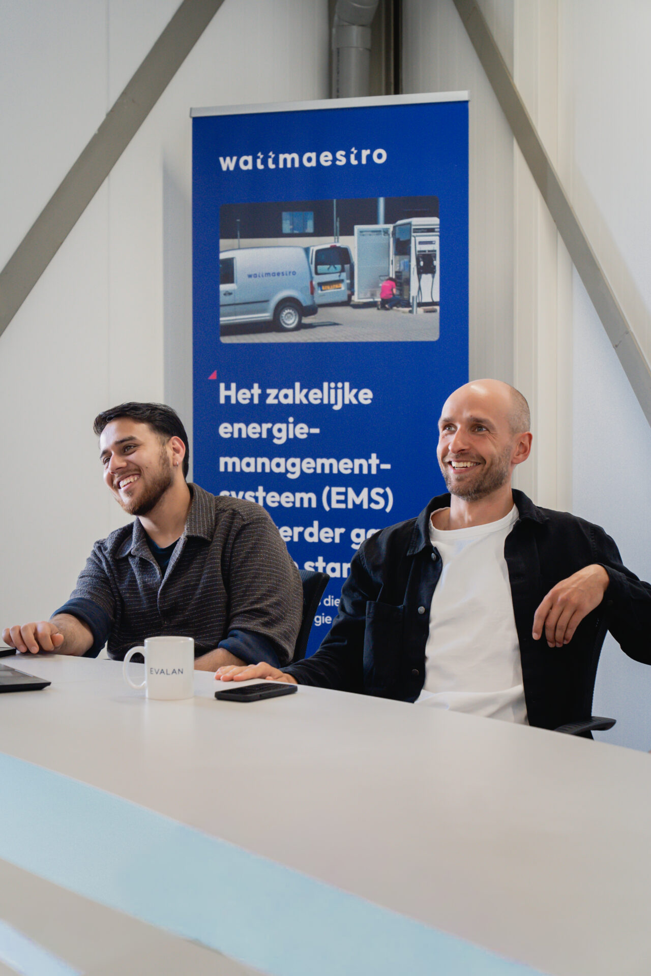 Wattmaestro team in a meeting, discussing EMS deployment with the Wattmaestro banner in the background
